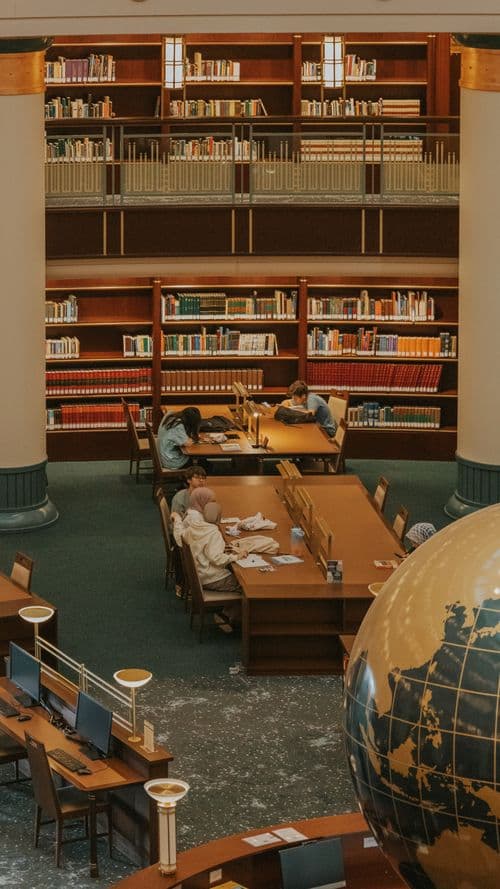 A student writing notes in a library — share your story with TSC