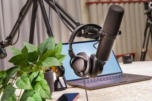 A modern podcast recording setup with microphone and laptop