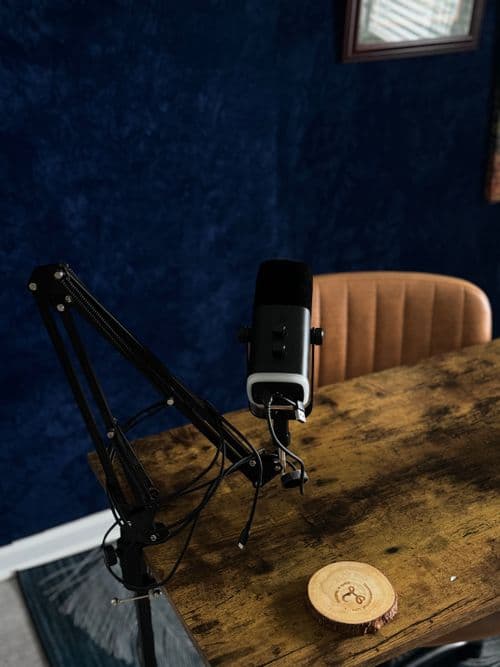 A microphone on a wooden desk in a recording studio