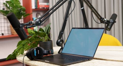 A podcast studio desk with microphones and headphones