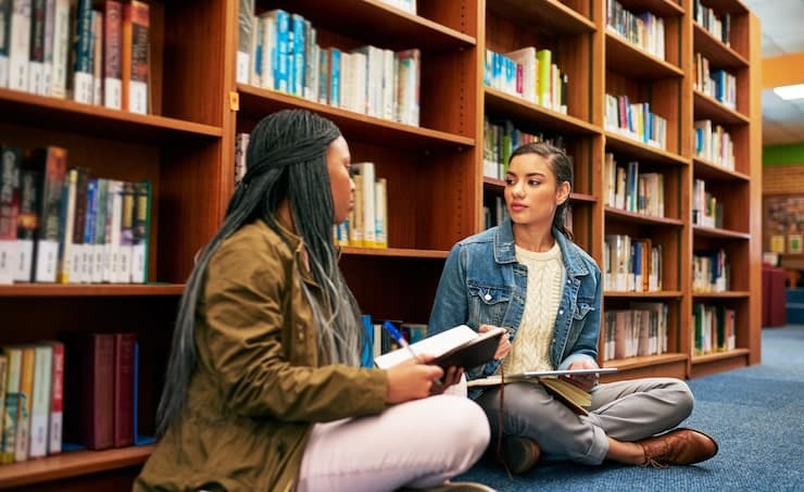 Students working with books and laptops in a modern study space